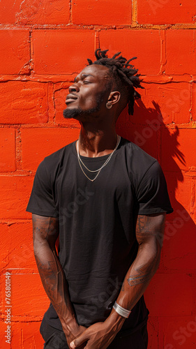 Portrait of African attractive man against background of red brick wall