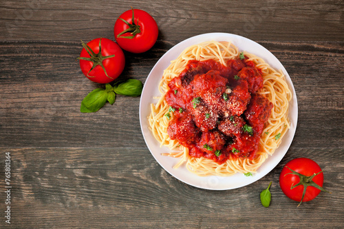Homemade spaghetti and meatballs with tomato sauce. Above view table scene on a dark wood background.