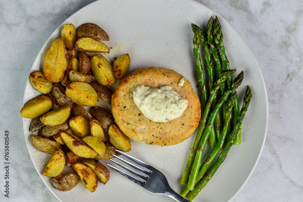 salmon burger with sayteed asparagus and potato wedges,