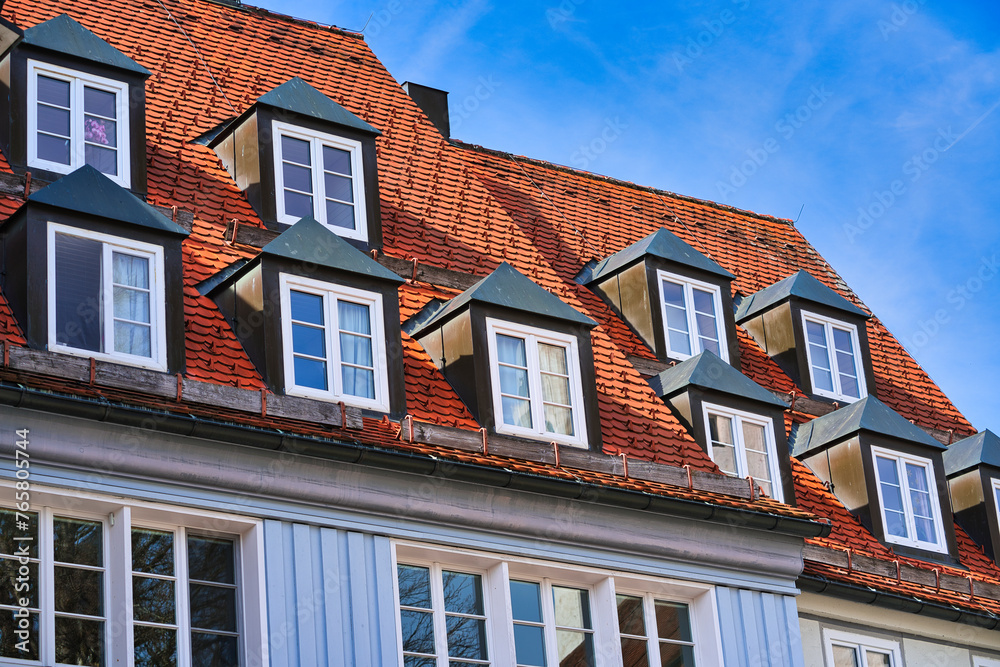 typical dormer windows of a German town on a pitched roof and orange tiles typical dormer windows of a German town on a pitched roof and orange tiles