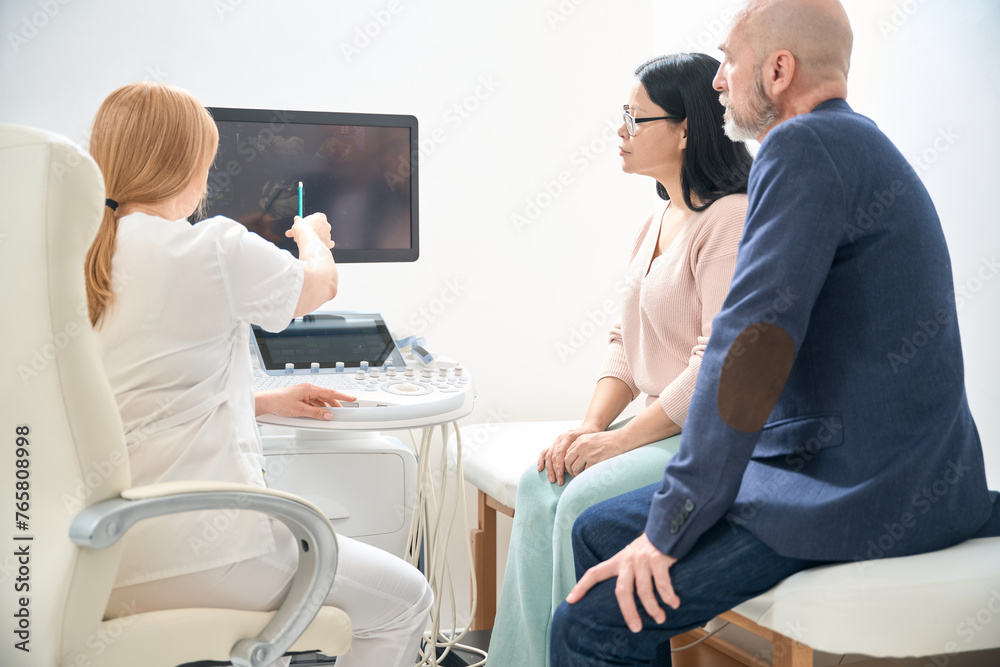 Fototapeta premium High-qualified physician talking to future parents after ultrasound