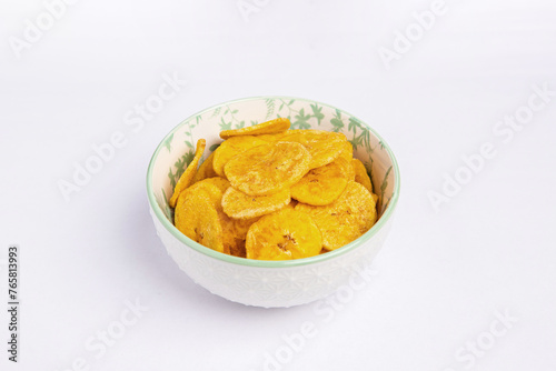 Green banana chips on white background