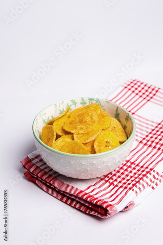 Green banana chips on cloth and white background