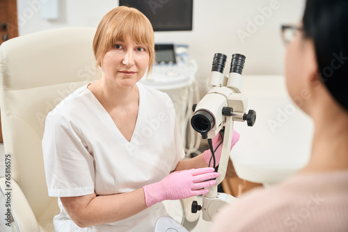 Qualified doctor gynecologist going to do gynecological examination of patient photo