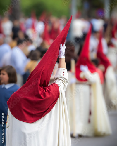 Nazareno, bearer in a procession of the easter week in Seville, andalusia, Spain. 2024 Semana Santa. Red hood, procession of 23.03.2024 photo