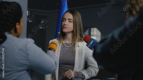 European female politician answers journalists questions and gives interview for media in European Parliament building. Representative of the European Union at TV press conference. Hot button issues. photo