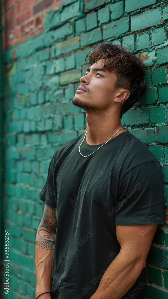 Portrait of Asian attractive man against background of green brick wall Portrait of Asian attractive man against background of green brick wall