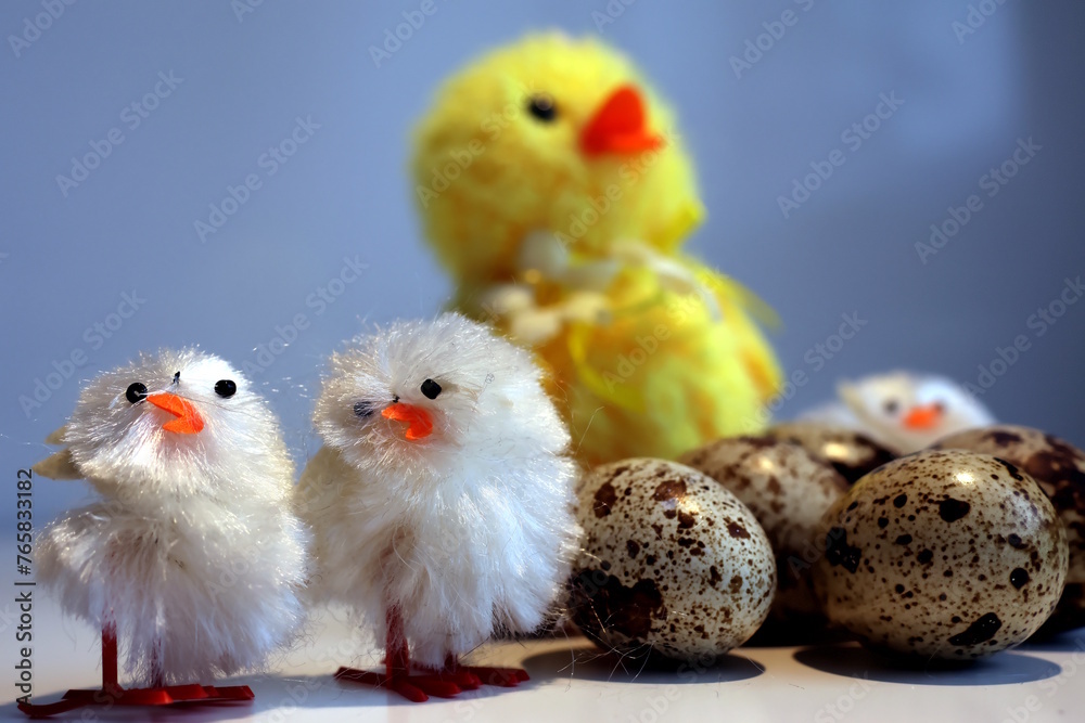 Toy chickens next to quail eggs look like one big family.
