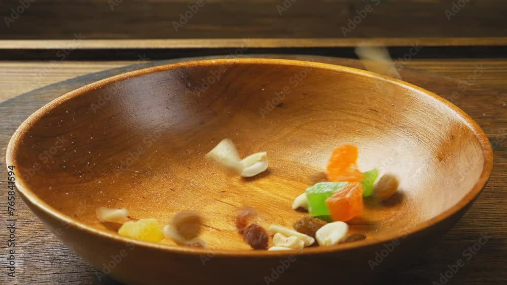dried fruits candied fruits and nuts fall into a wooden plate rotating in a circle. Medium plan. dried fruits candied fruits and nuts fall into a wooden plate rotating in a circle. Medium plan.