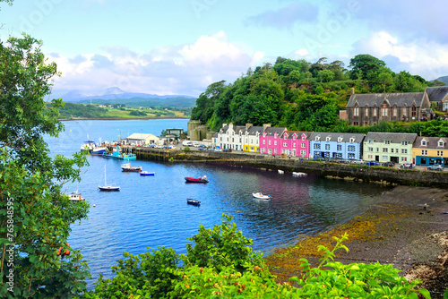 Colorful coastal fishing village of Portree, Isle of Skye, Scotland. Looking over the boat filled harbor at dusk.