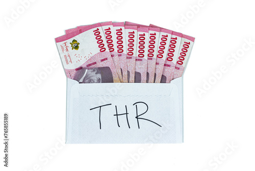 Indonesian rupiah currency. White envelope with THR Text containing stack of IDR 100,000 cash.THR is holiday allowance on Eid al-Fitr or Lebaran days.