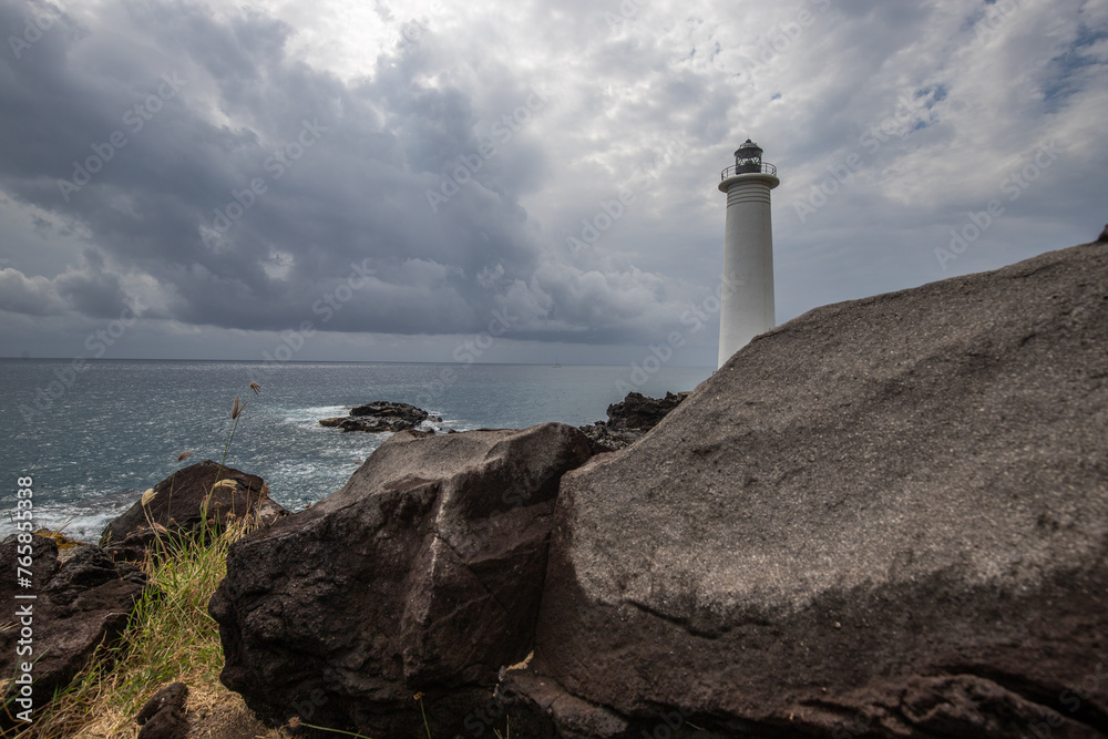 Le Phare du Vieux-Fort, white lighthouse on a cliff. Dramatic clouds overlooking the sea. Pure Caribbean on Guadeloupe, French Antilles, France - obrazy, fototapety, plakaty 