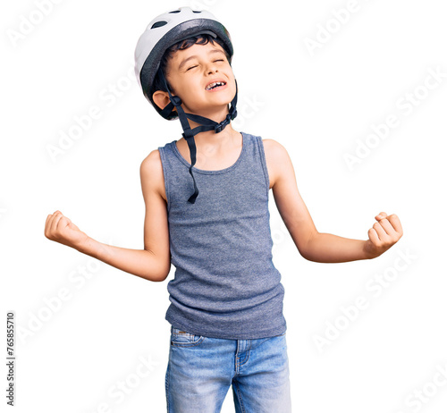Little cute boy kid wearing bike helmet very happy and excited doing winner gesture with arms raised, smiling and screaming for success. celebration concept.
