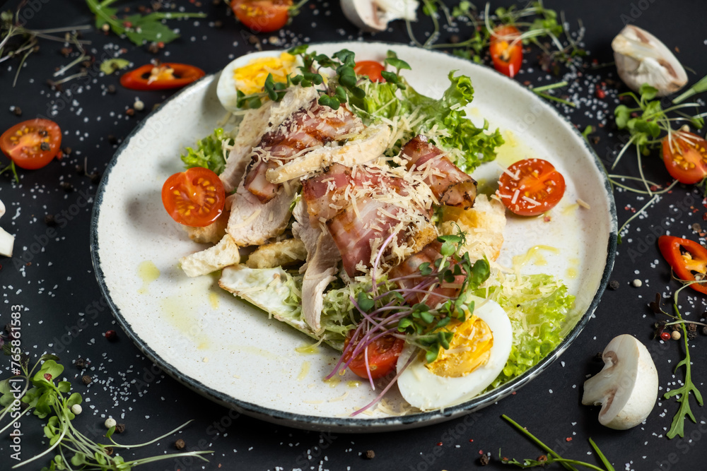 Fresh caesar salad in white plate on dark wooden table. Top view. Fresh caesar salad in white plate on dark wooden table. Top view.