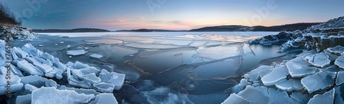 A large body of water covered in thick sheets of ice, with the frozen surface extending to the shorelines photo