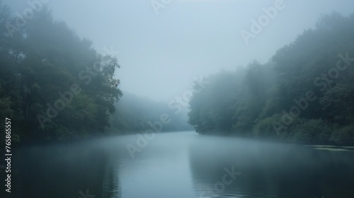 A dense fog rolling over a tranquil river, shrouding the landscape in an ethereal mist