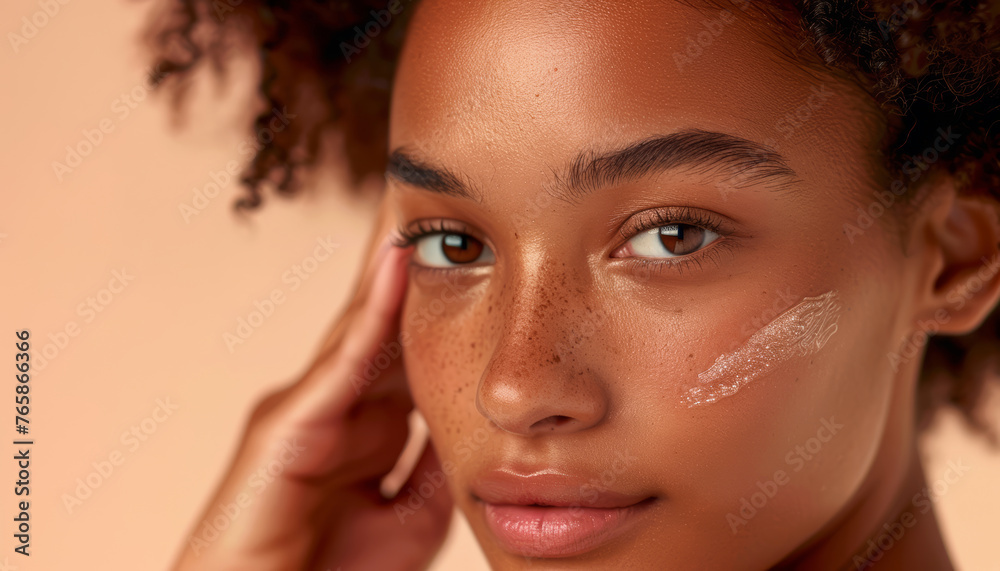 Giovane donna con la pelle radiosa che applica delicatamente una crema idratante sul viso. Trattamenti di bellezza e cura della pelle. Giovane donna con la pelle radiosa che applica delicatamente una crema idratante sul viso. Trattamenti di bellezza e cura della pelle.