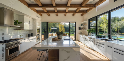 White kitchen with island, large windows in background