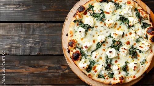  a pizza topped with cheese and spinach on top of a wooden plate on top of a wooden table next to a bottle of wine.