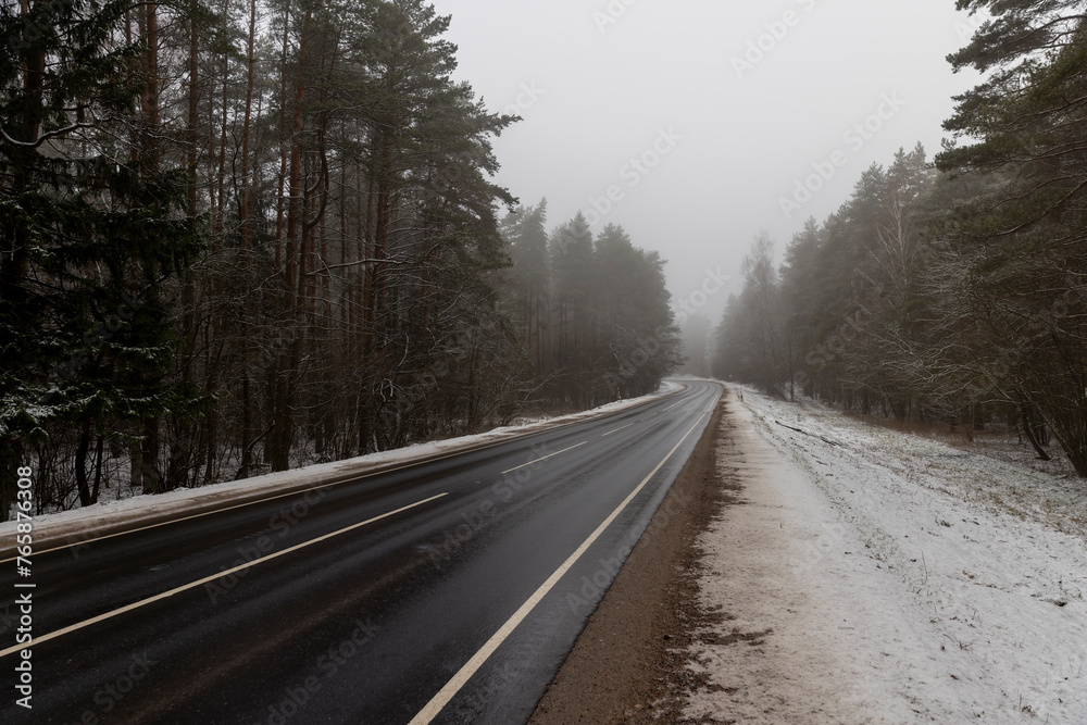 Fototapeta premium beautiful snow-covered road during fog in winter