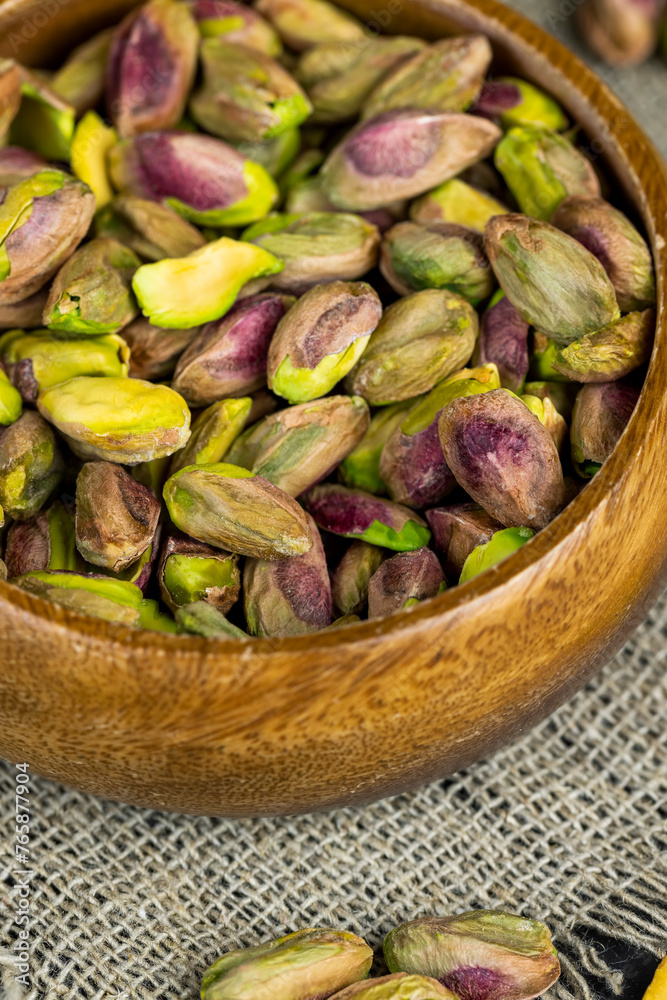 peeled pistachios in a wooden bowl, close-up peeled pistachios in a wooden bowl, close-up