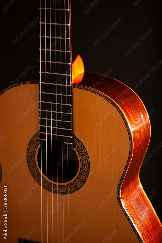 Classical Spanish flamenco guitar close up, dramatically lit isolated on black background with copy space.