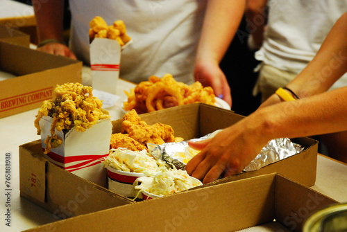Workers at a seafood restaurant quickly prepare and package a meal during a busy night