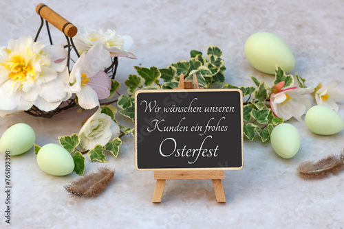 Grußkarte Frohe Ostern: Blumen mit Ostereiern und der Beschriftung wir wünschen ein frohes Osterfest auf einem Rahmen.