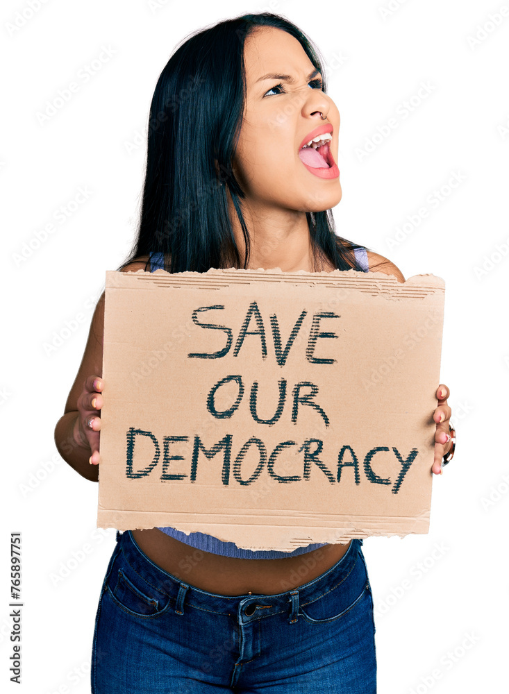 Beautiful hispanic woman holding save our democracy protest banner angry and mad screaming frustrated and furious, shouting with anger looking up. Beautiful hispanic woman holding save our democracy protest banner angry and mad screaming frustrated and furious, shouting with anger looking up.