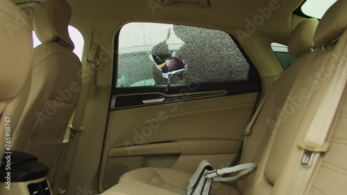 Criminal car thief smashes break car window snatches bag from back seat. Carjacker break window glass seizes opportunity swiftly grabbing stolen belongings Car thief break car window glasses.