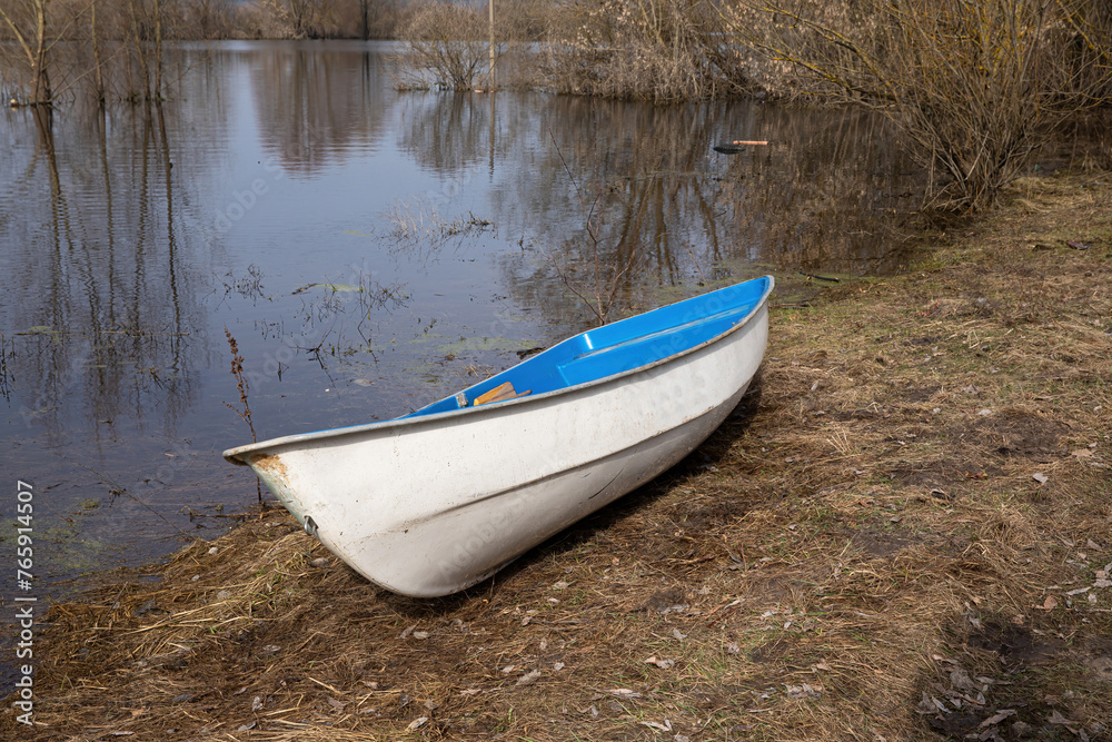 An empty boat on the shore of the overflowing floodplain of the river in spring. An empty boat on the shore of the overflowing floodplain of the river in spring.