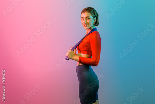 Full body length gaiety shot athletic and sporty young woman with fitness elastic resistance band in standing posture on isolated background. Healthy active and body care lifestyle.