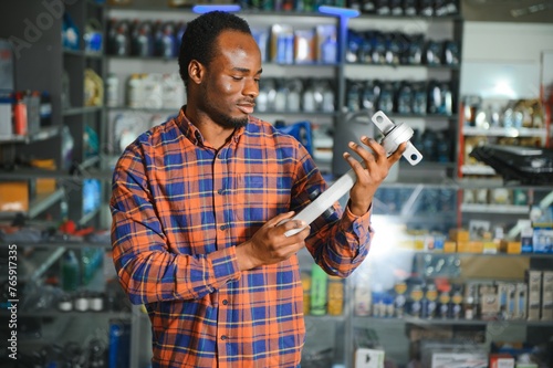 Portrait of a handsome african salesman in an auto parts store. The concept of car repair