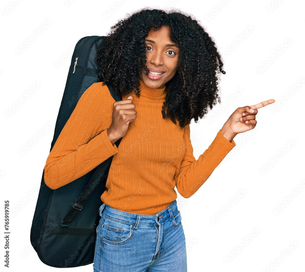 Young african american girl wearing guitar case smiling happy pointing with hand and finger to the side