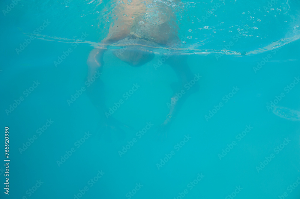 Man swim diving underwater in swimming pool on summer vacation. Swimming in pool. Blue