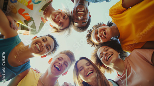 A circle of friends at a health center, mixed ethnicities, in casual clothes and running shoes, playfully embracing and looking down at the camera with bright, infectious laughter, photo