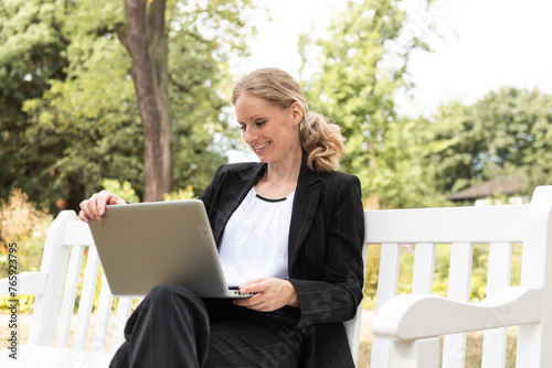 businesswoman with laptop in the park on a sunny day