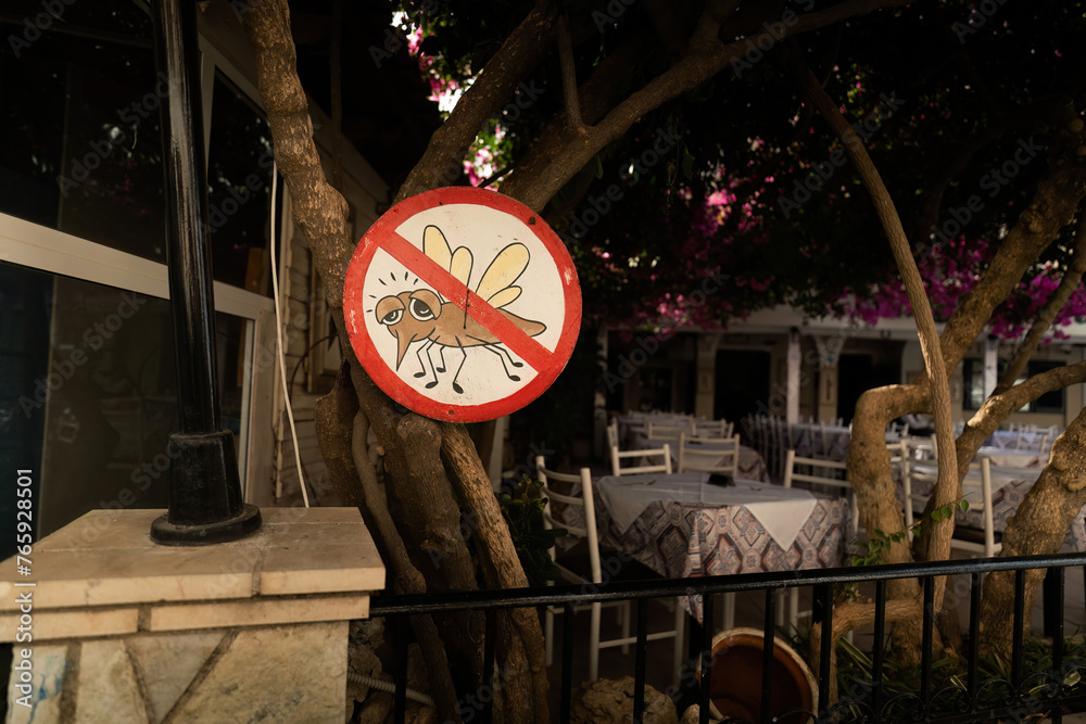 A restaurant with a sign stating mosquitoes are banned in Greece