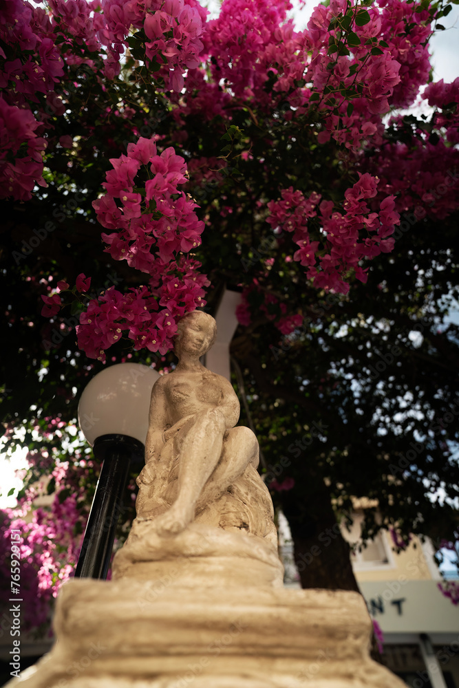 A typical sculpture next to street light against tree as a decorative monument in an entrace