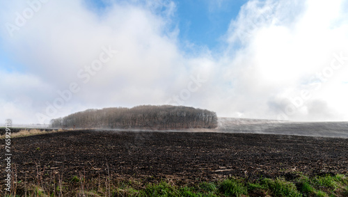 Spring landscape, agricultural land. Natural phenomenon. Foggy morning, the ground is steaming
