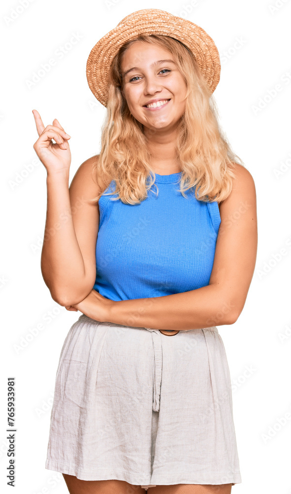 Young blonde girl wearing summer hat smiling happy pointing with hand and finger to the side Young blonde girl wearing summer hat smiling happy pointing with hand and finger to the side
