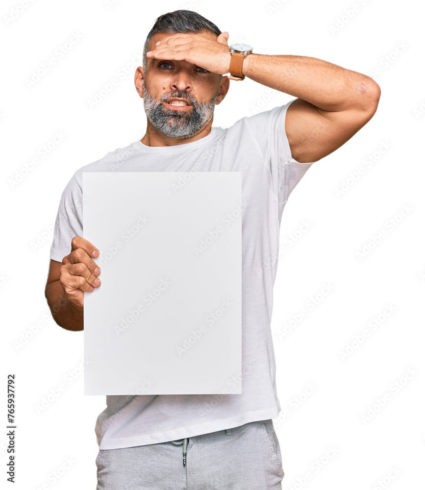 Middle age handsome man holding blank empty banner stressed and frustrated with hand on head, surprised and angry face