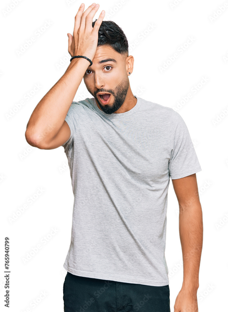 Young man with beard wearing casual grey tshirt surprised with hand on head for mistake, remember error. forgot, bad memory concept. Young man with beard wearing casual grey tshirt surprised with hand on head for mistake, remember error. forgot, bad memory concept.