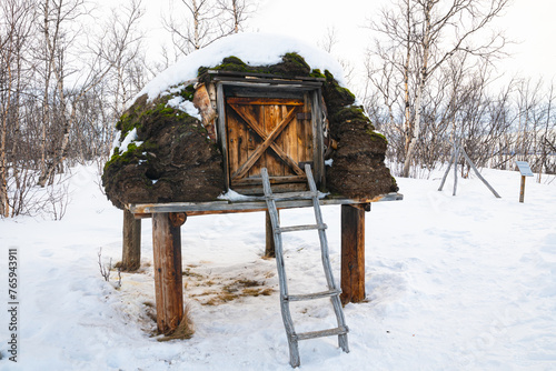 Scenic image of a raised wooden cottage with stairs in a Saami camp near Abisko in northern Sweden