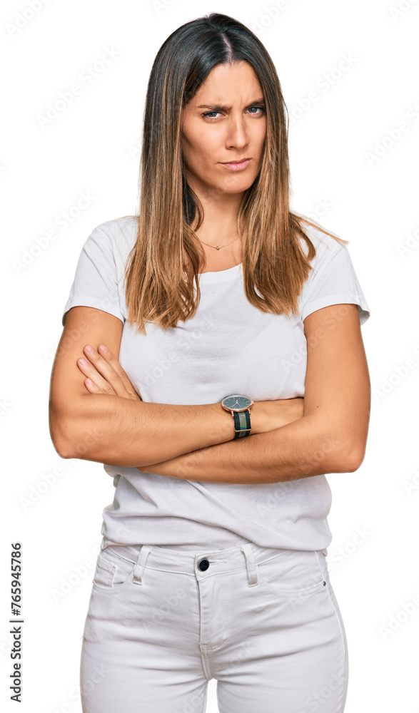 Young woman wearing casual white t shirt skeptic and nervous, disapproving expression on face with crossed arms. negative person. Young woman wearing casual white t shirt skeptic and nervous, disapproving expression on face with crossed arms. negative person.