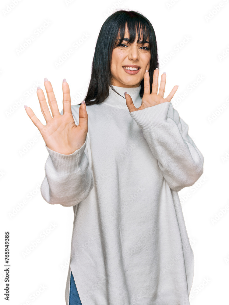 Young brunette woman with bangs wearing casual turtleneck sweater afraid and terrified with fear expression stop gesture with hands, shouting in shock. panic concept. Young brunette woman with bangs wearing casual turtleneck sweater afraid and terrified with fear expression stop gesture with hands, shouting in shock. panic concept.
