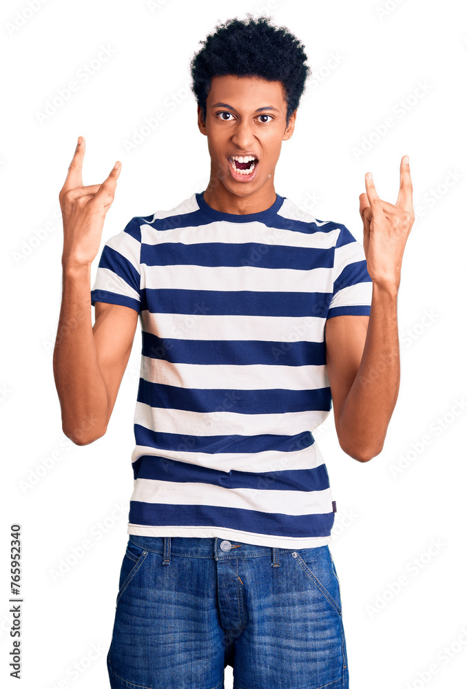 Young african american man wearing casual clothes shouting with crazy expression doing rock symbol with hands up. music star. heavy concept. Young african american man wearing casual clothes shouting with crazy expression doing rock symbol with hands up. music star. heavy concept.