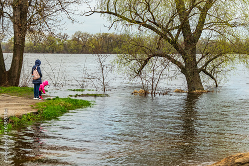 The Dnieper River overflowed its banks during the spring flood, when the water level rises and floods the bank and trees