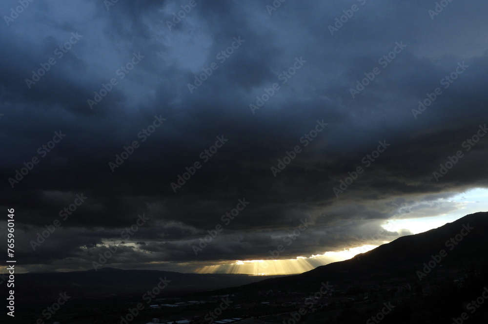 dark clouds coming from behind the mountains, it's going to rain