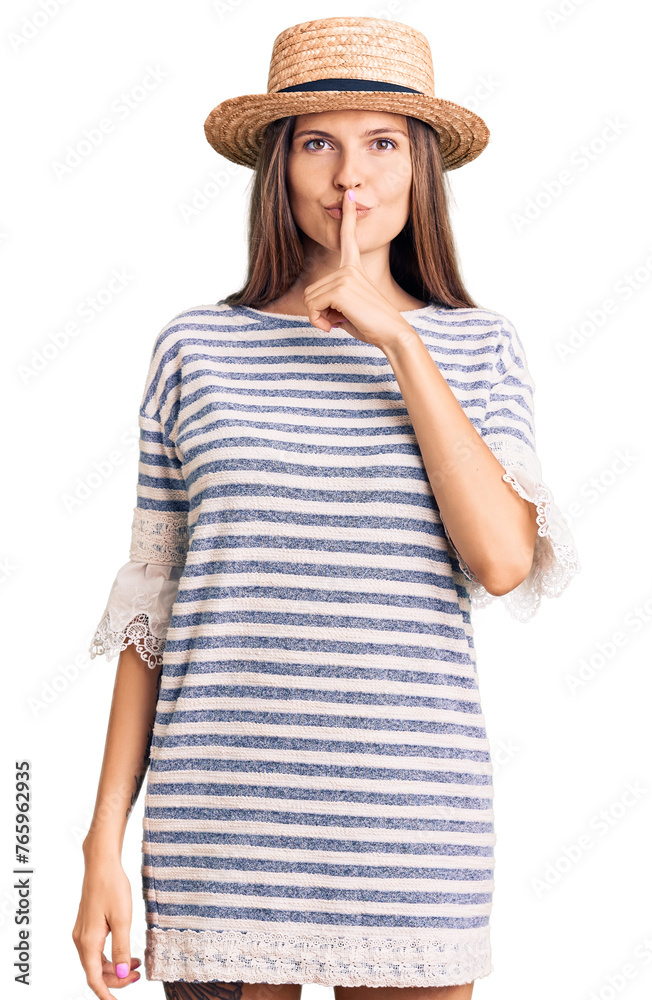 Beautiful caucasian woman wearing summer hat asking to be quiet with finger on lips. silence and secret concept. Beautiful caucasian woman wearing summer hat asking to be quiet with finger on lips. silence and secret concept.